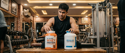 Indian gym-goer comparing all in one whey protein and regular whey protein tubs on a gym bench