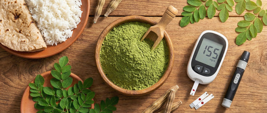 A flat-lay photograph of moringa leaf powder in a bowl, a blood sugar monitor showing a post-meal reading, and a plate with rice and roti on a wooden table, illustrating natural diabetes management in an Indian diet context.
