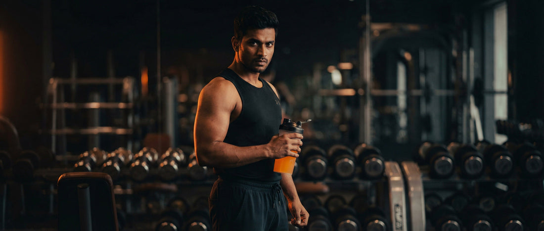 Indian man taking pre-workout supplement before gym workout