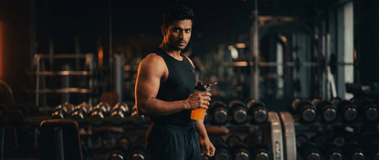 Indian man taking pre-workout supplement before gym workout