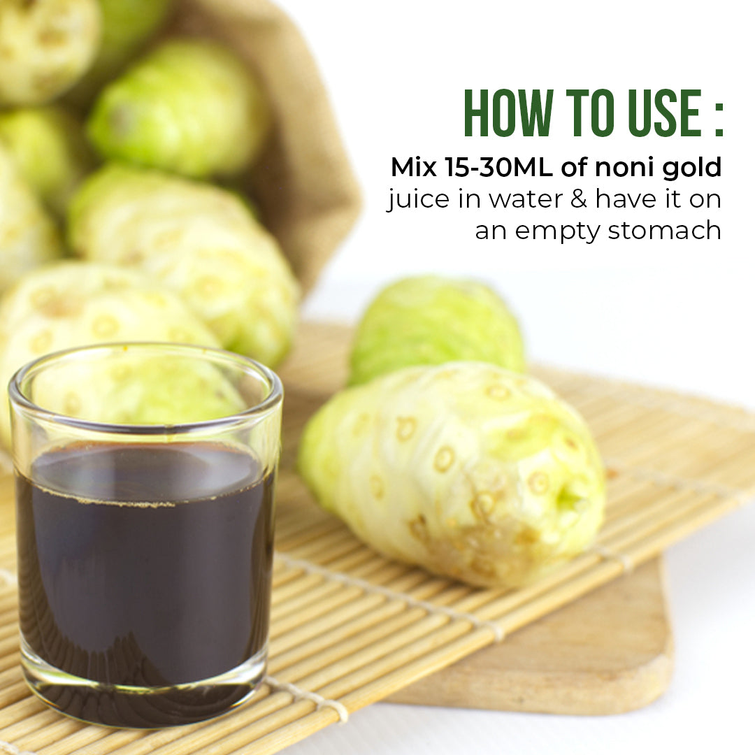 Glass of Noni Gold juice with fresh noni fruits illustrating the recommended way to consume noni juice.